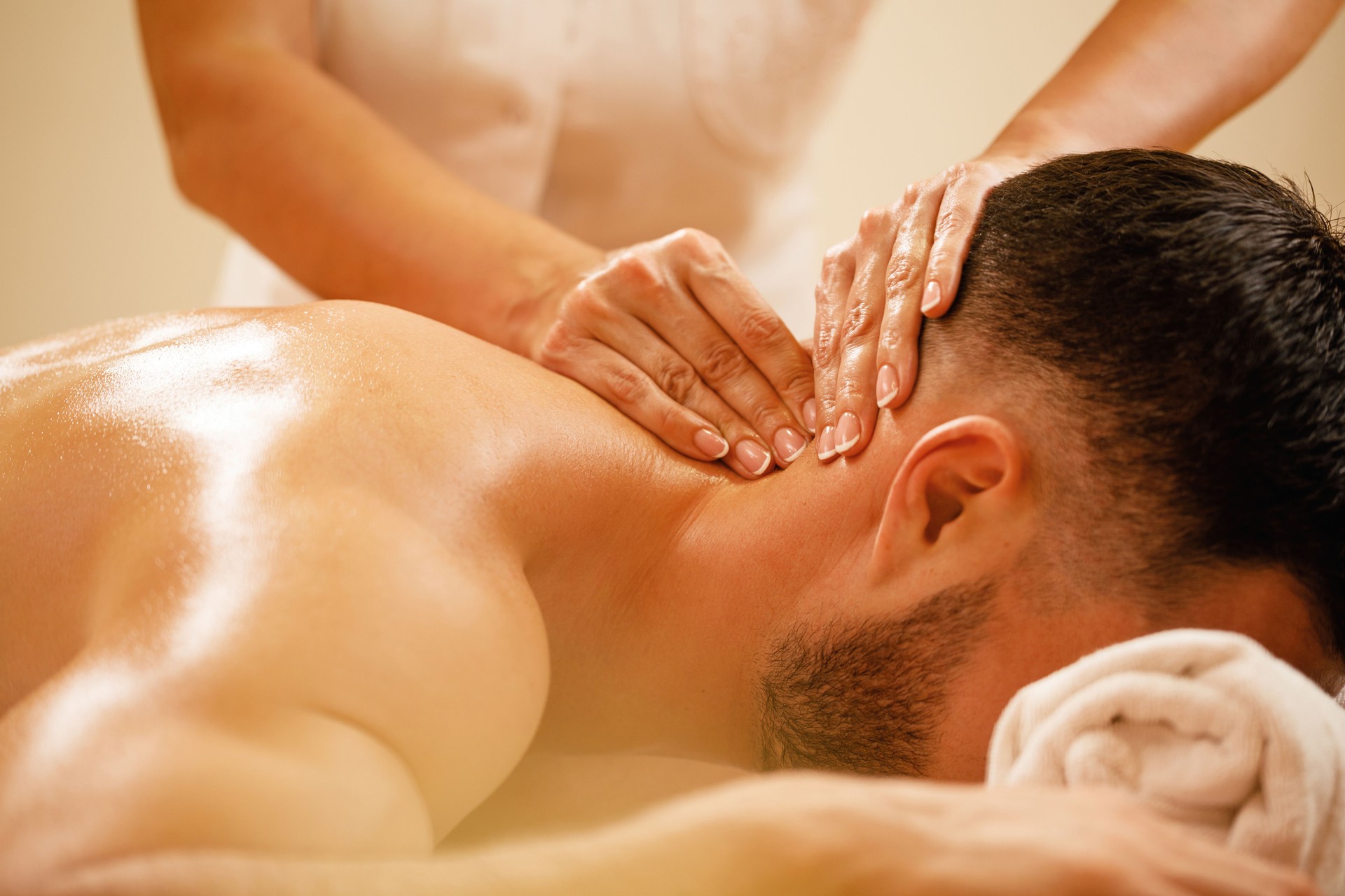 Close-up of man having neck massage at health spa.